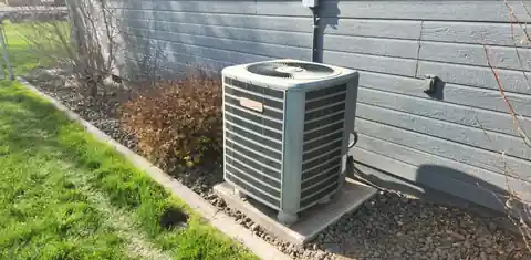 Older outdoor unit against blue siding