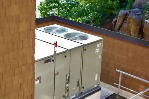 Two packaged rooftop units on a shingled commercial roof
